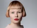 Mujer con pelo corto con flequillo desfilado, ojos azules y labios rojos.