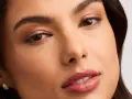 Rostro de mujer con un sutil maquillaje nude, resaltando sus ojos y labios con un toque natural y elegante.