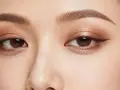 Ojos con un sutil maquillaje ahumado natural, delineado fino y cejas definidas.