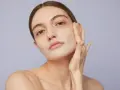Mujer aplicándose crema para saber como exfoliar la piel. Suave masaje facial para una piel radiante.