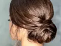 Moño bajo despeinado con mechones sueltos, un estilo elegante y natural para cualquier ocasión.