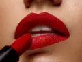 Labios perfectamente definidos con un intenso maquillaje de labios rojos, aplicados con un labial carmesí.