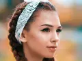 Chica con trenzas y pañuelo, mostrando cómo pintar la raya del ojo con delineado cat eye perfecto.
