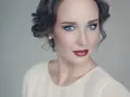 Maquillaje para vestido blanco: ojos ahumados y labios rojos intensos, peinado recogido con rizos.