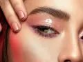 Ojo con maquillaje rosa brillante y cejas laminadas. ¿Cuánto dura el laminado de cejas?