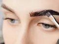 Aplicando tinte oscuro para que se puedan teñir las cejas y darles más definición.