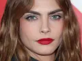 Primer plano de una mujer con cejas pobladas y labios rojos. ¿Recortar cejas sí o no? La decisión es tuya.