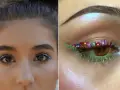 Ojo maquillaje hippie con flores y brillos. Delineado verde con pétalos de colores y pestañas inferiores neón.