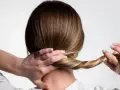 Manos trenzando el cabello, un peinado sencillo para dormir que protege tu melena.