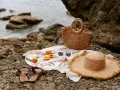 Accesorios de playa: sombrero, bolso, chanclas, gafas de sol y albaricoques, ideales para saber como mantener el moreno de playa.