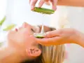 Manos aplicando gel de aloe vera para la cara de una mujer, un tratamiento natural para la piel.
