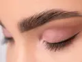 Ojo cerrado con sombra rosa, delineado cat eye y cejas separadas bien definidas.