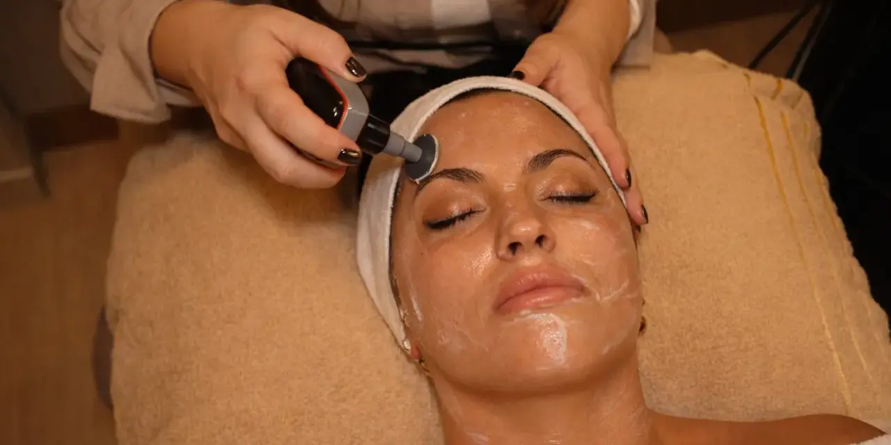 Una mujer recibe un tratamiento facial con un dispositivo de radiofrecuencia. El protocolo radiofrecuencia facial se aplica para rejuvenecer la piel.