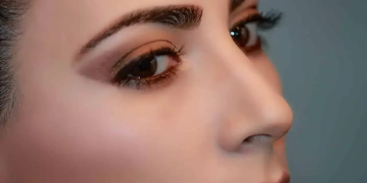 Primer plano de un ojo y nariz de mujer con cejas definidas. La pregunta es: cuanto dura la henna en las cejas.