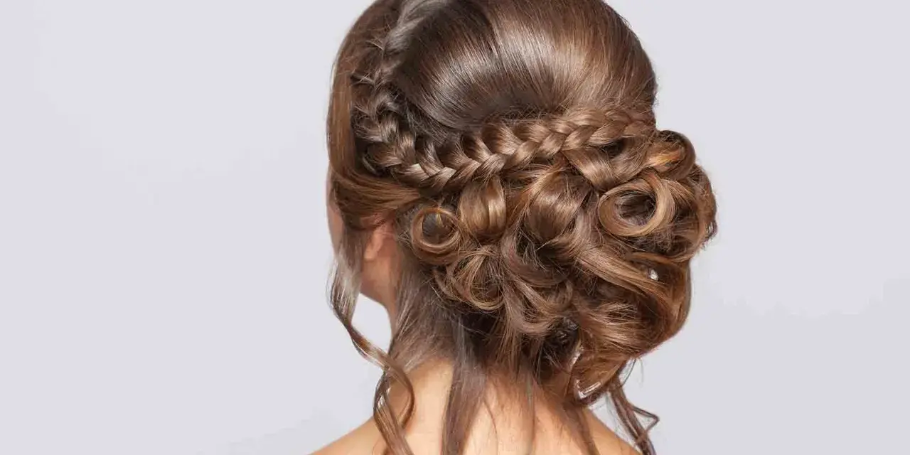 Peinado de novia con trenzas y rizos sueltos, un look romántico y elegante para tu gran día.