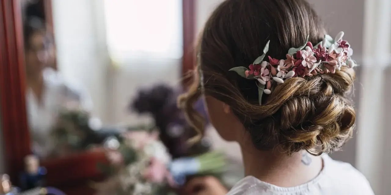 Un elegante moño bajo adornado con flores delicadas, perfecto para un día especial.