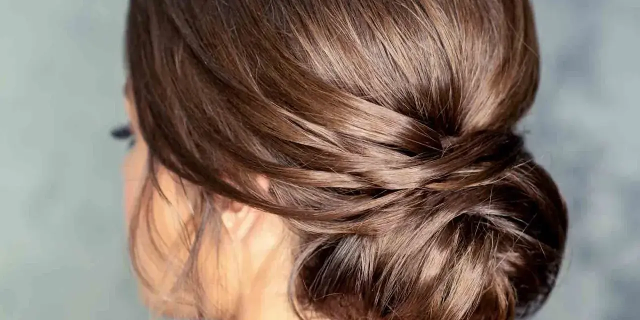 Moño bajo despeinado con mechones sueltos, un estilo elegante y natural para cualquier ocasión.