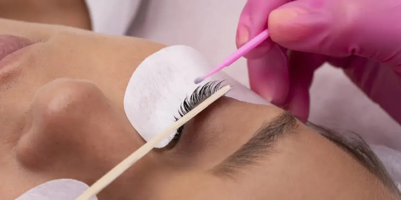 Manos enguantadas aplican producto para un lifting de pestañas, logrando un efecto espectacular sin inconvenientes.
