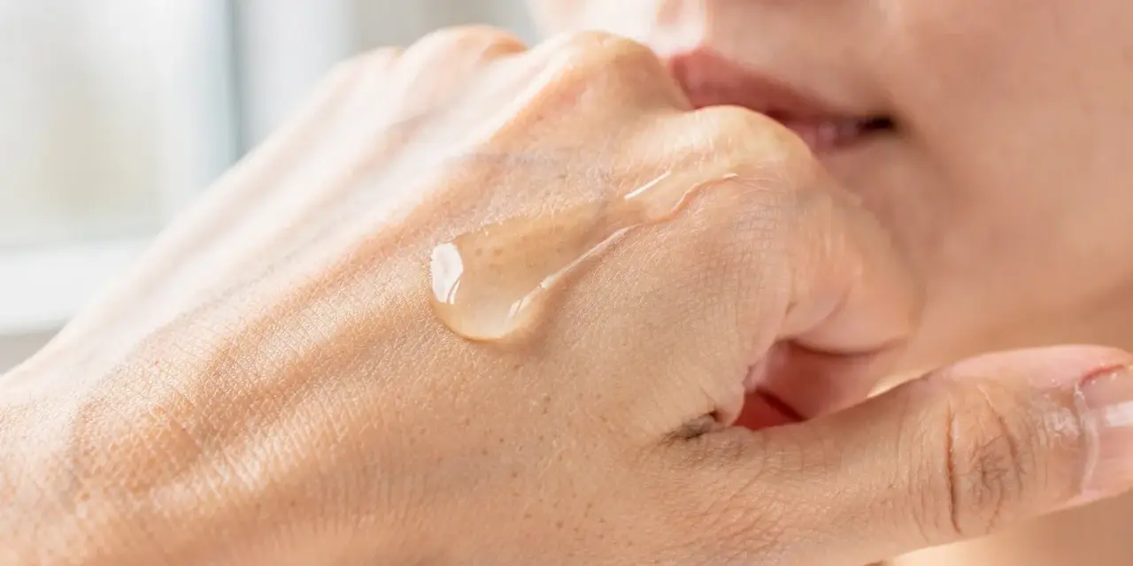 Gota de serum de vitamina C sobre la mano, mostrando para que sirve la vitamina c serum: hidratación y luminosidad.