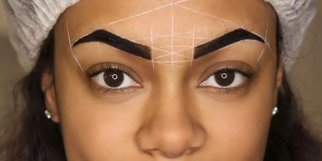 Ojos y cejas marcadas con líneas blancas para diseño. Se observa una posible alergia a la henna en las cejas.