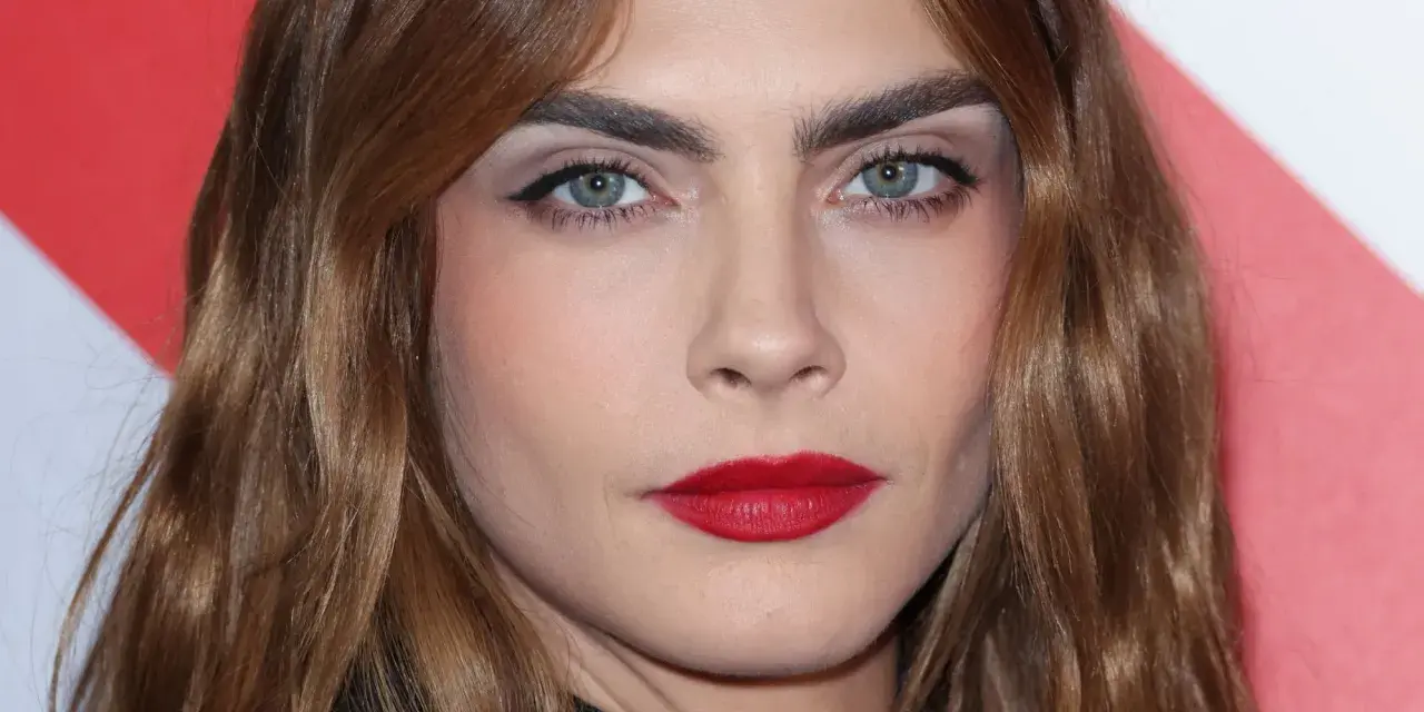 Primer plano de una mujer con cejas pobladas y labios rojos. ¿Recortar cejas sí o no? La decisión es tuya.