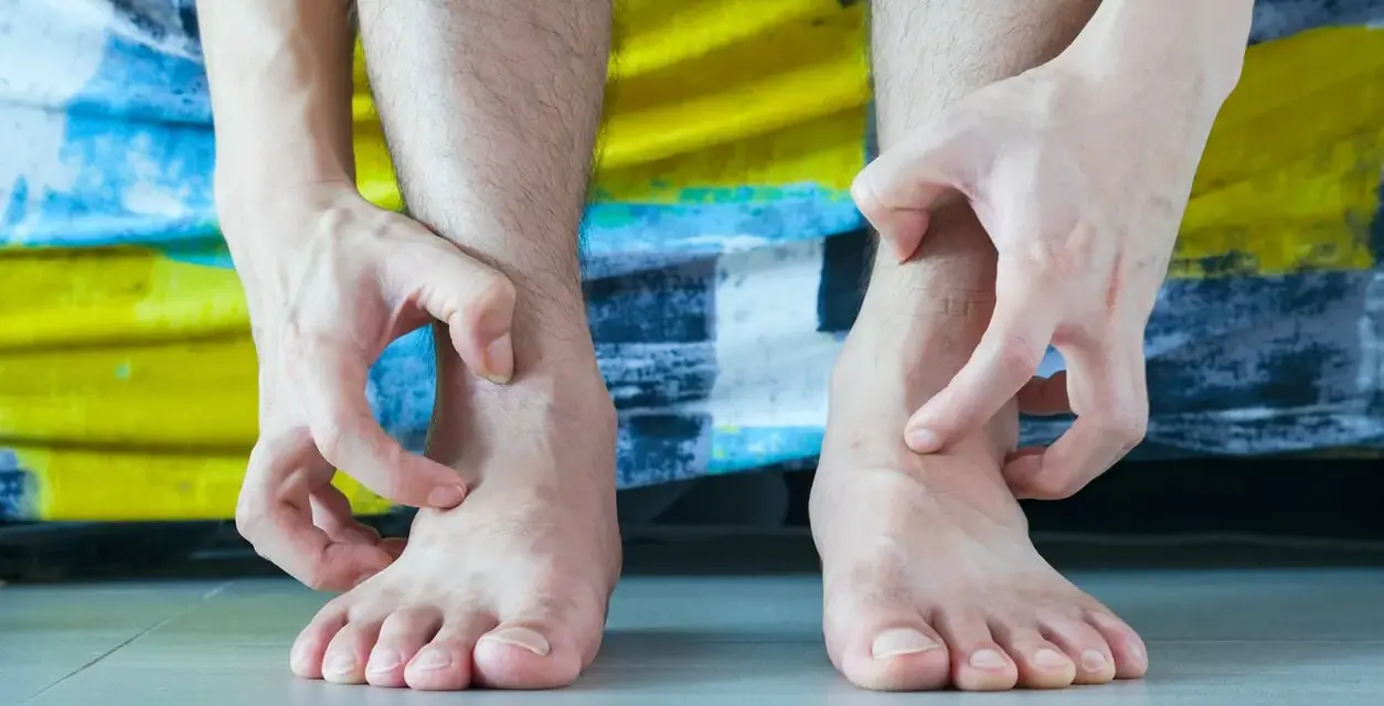 Man se rasca los tobillos, preguntándose por que me pican las piernas.