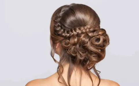 Peinado de novia con trenzas y rizos sueltos, un look romántico y elegante para tu gran día.