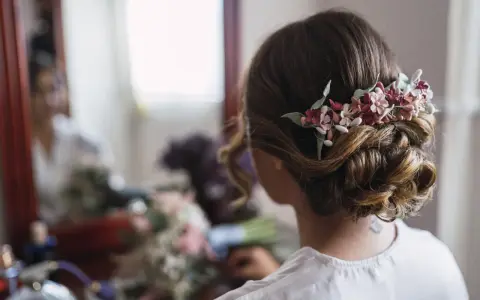 Un elegante moño bajo adornado con flores delicadas, perfecto para un día especial.