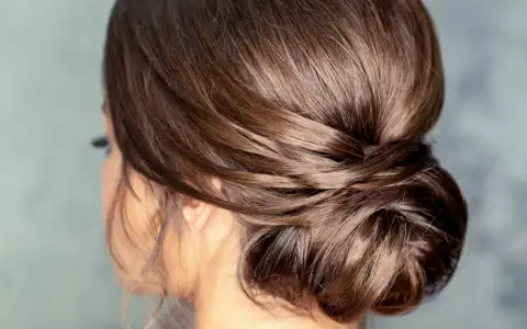Moño bajo despeinado con mechones sueltos, un estilo elegante y natural para cualquier ocasión.