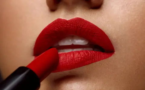 Labios perfectamente definidos con un intenso maquillaje de labios rojos, aplicados con un labial carmesí.