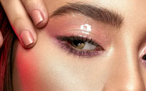 Ojo con maquillaje rosa brillante y cejas laminadas. ¿Cuánto dura el laminado de cejas?