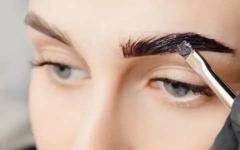 Aplicando tinte oscuro para que se puedan teñir las cejas y darles más definición.