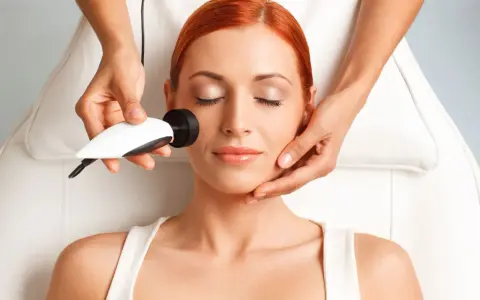 Mujer recibiendo tratamiento de radiofrecuencia facial. La cantidad de cuantas sesiones de radiofrecuencia facial son necesarias varía según el caso.