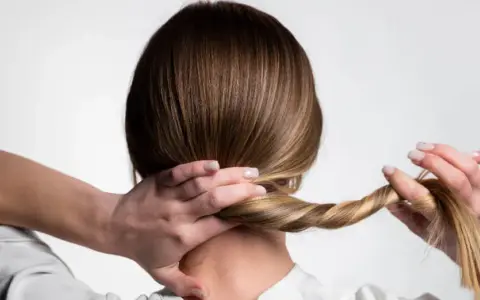 Manos trenzando el cabello, un peinado sencillo para dormir que protege tu melena.