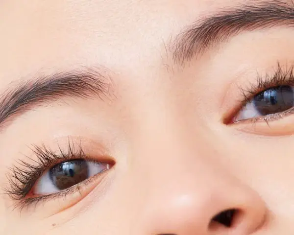 Ojos marcados con pestañas largas y cejas definidas.