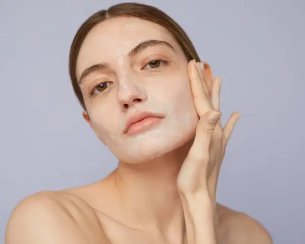Mujer aplicándose crema para saber como exfoliar la piel. Suave masaje facial para una piel radiante.
