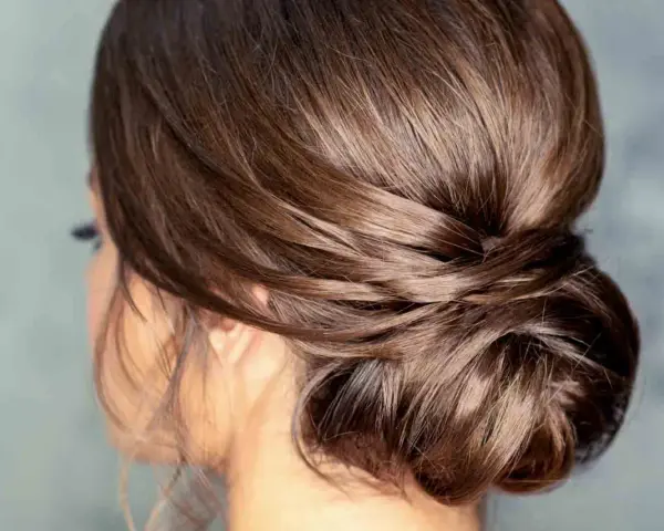 Moño bajo despeinado con mechones sueltos, un estilo elegante y natural para cualquier ocasión.
