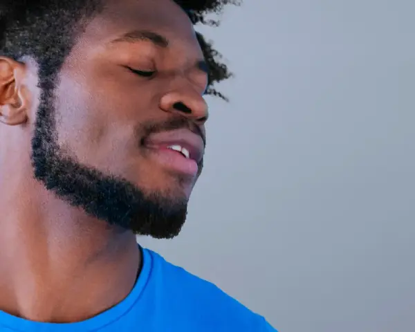 Hombre con perilla barba y ojos cerrados, disfrutando un momento de paz.