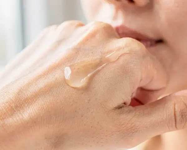 Gota de serum de vitamina C sobre la mano, mostrando para que sirve la vitamina c serum: hidratación y luminosidad.
