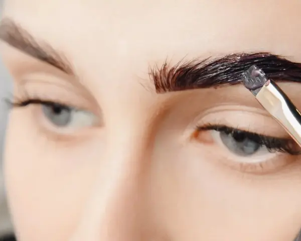 Aplicando tinte oscuro para que se puedan teñir las cejas y darles más definición.