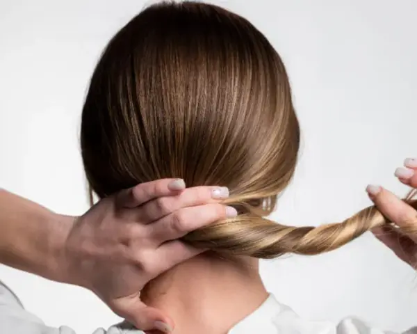 Manos trenzando el cabello, un peinado sencillo para dormir que protege tu melena.