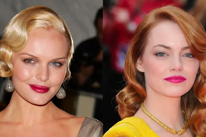 Dos mujeres con peinados años 20 pelo largo, ondas marcadas y labios intensos. Una rubia con pendientes brillantes, la otra pelirroja con collar dorado.