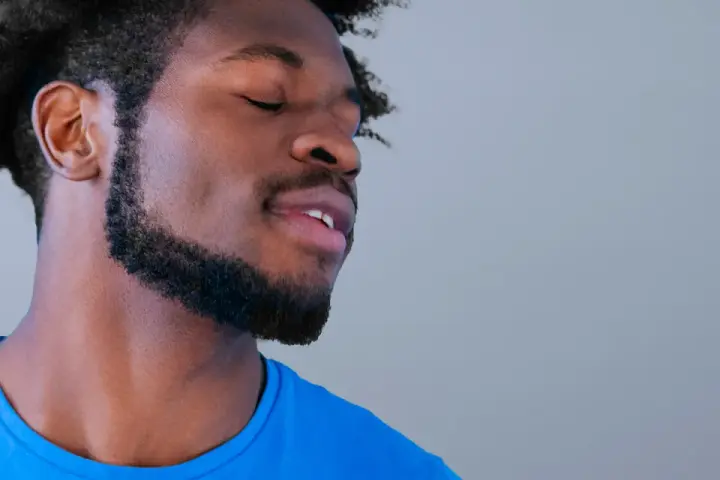 Hombre con perilla barba y ojos cerrados, disfrutando un momento de paz.