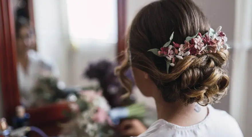 Un elegante moño bajo adornado con flores delicadas, perfecto para un día especial.