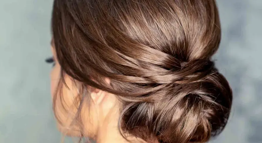 Moño bajo despeinado con mechones sueltos, un estilo elegante y natural para cualquier ocasión.