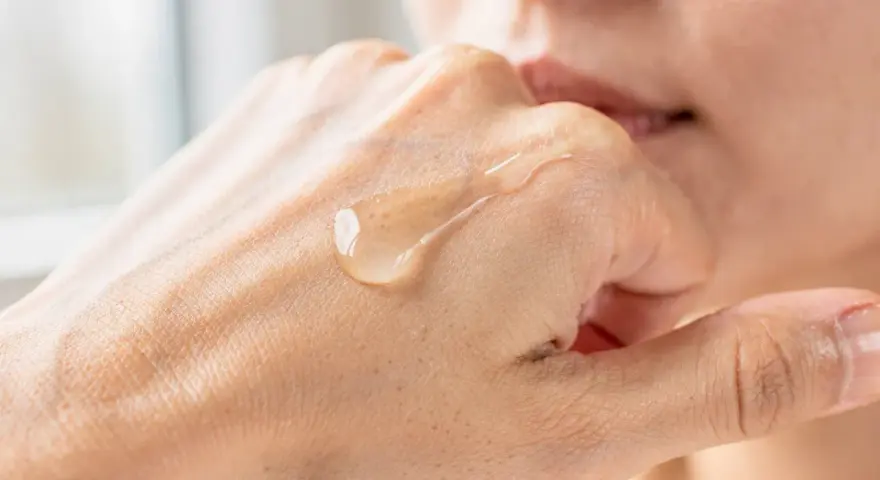 Gota de serum de vitamina C sobre la mano, mostrando para que sirve la vitamina c serum: hidratación y luminosidad.