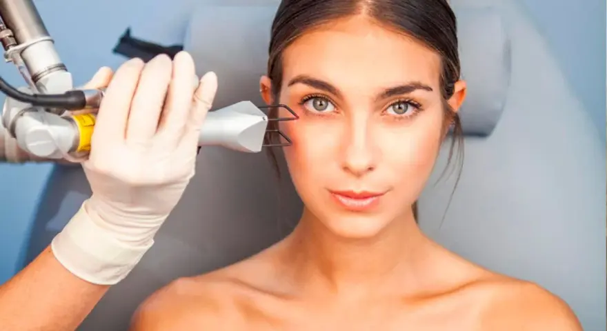 Tratamiento láser para ojera vascular. Una mano enguantada aplica un dispositivo en la zona del ojo de una mujer.