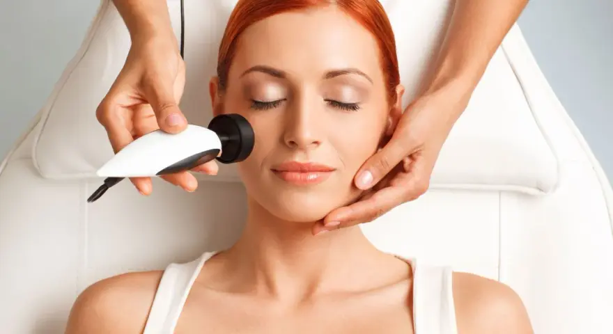 Mujer recibiendo tratamiento de radiofrecuencia facial. La cantidad de cuantas sesiones de radiofrecuencia facial son necesarias varía según el caso.