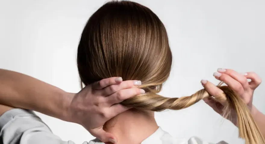 Manos trenzando el cabello, un peinado sencillo para dormir que protege tu melena.