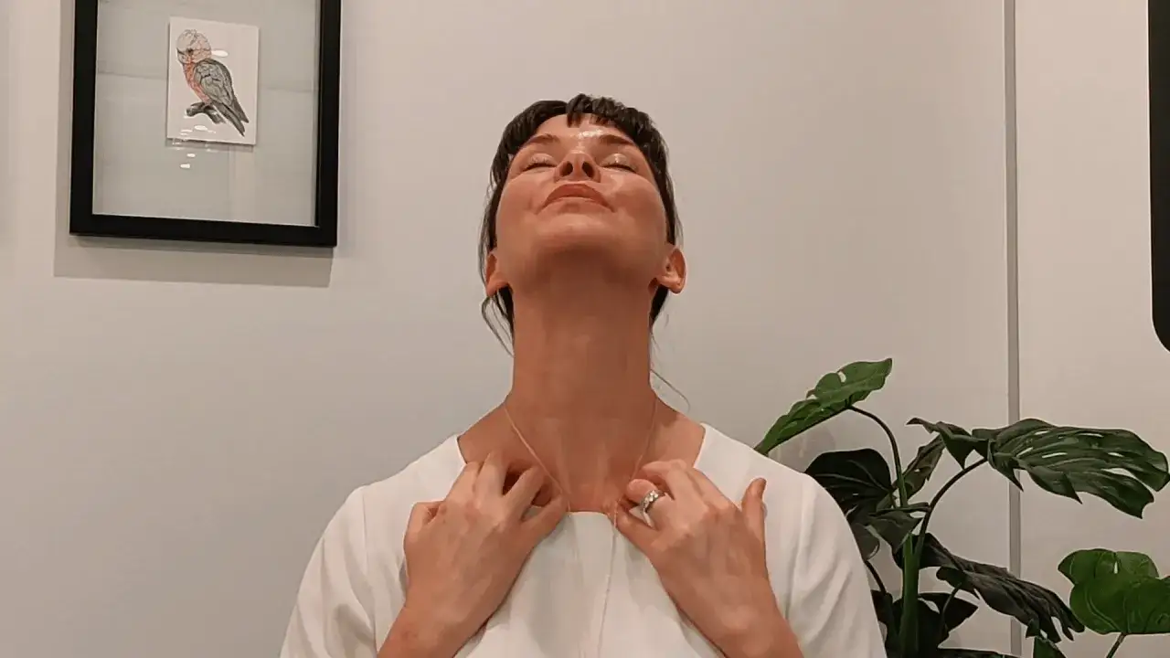 Mujer realizando ejercicios facial para flacidez cara, estirando el cuello hacia atrás.